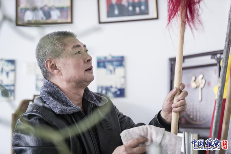 陈桂学擦拭着练功房中的兵器，这些兵器很多是父辈们留下来的。李鑫 摄